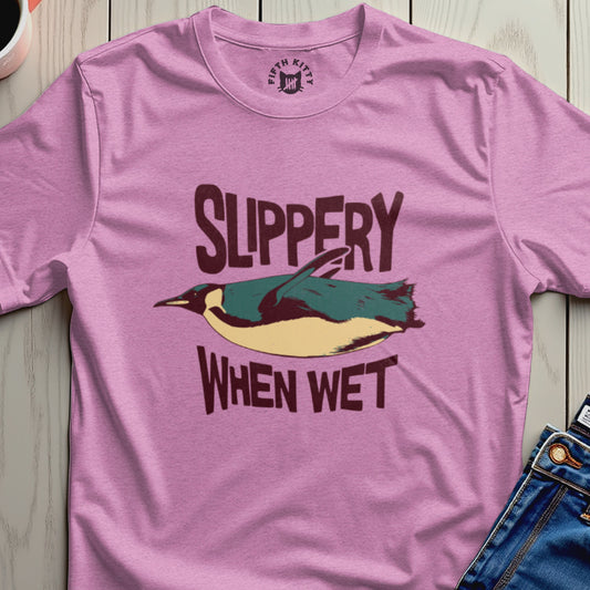 Pink t-shirt with a graphic of a penguin and text "SLIPPERY WHEN WET".