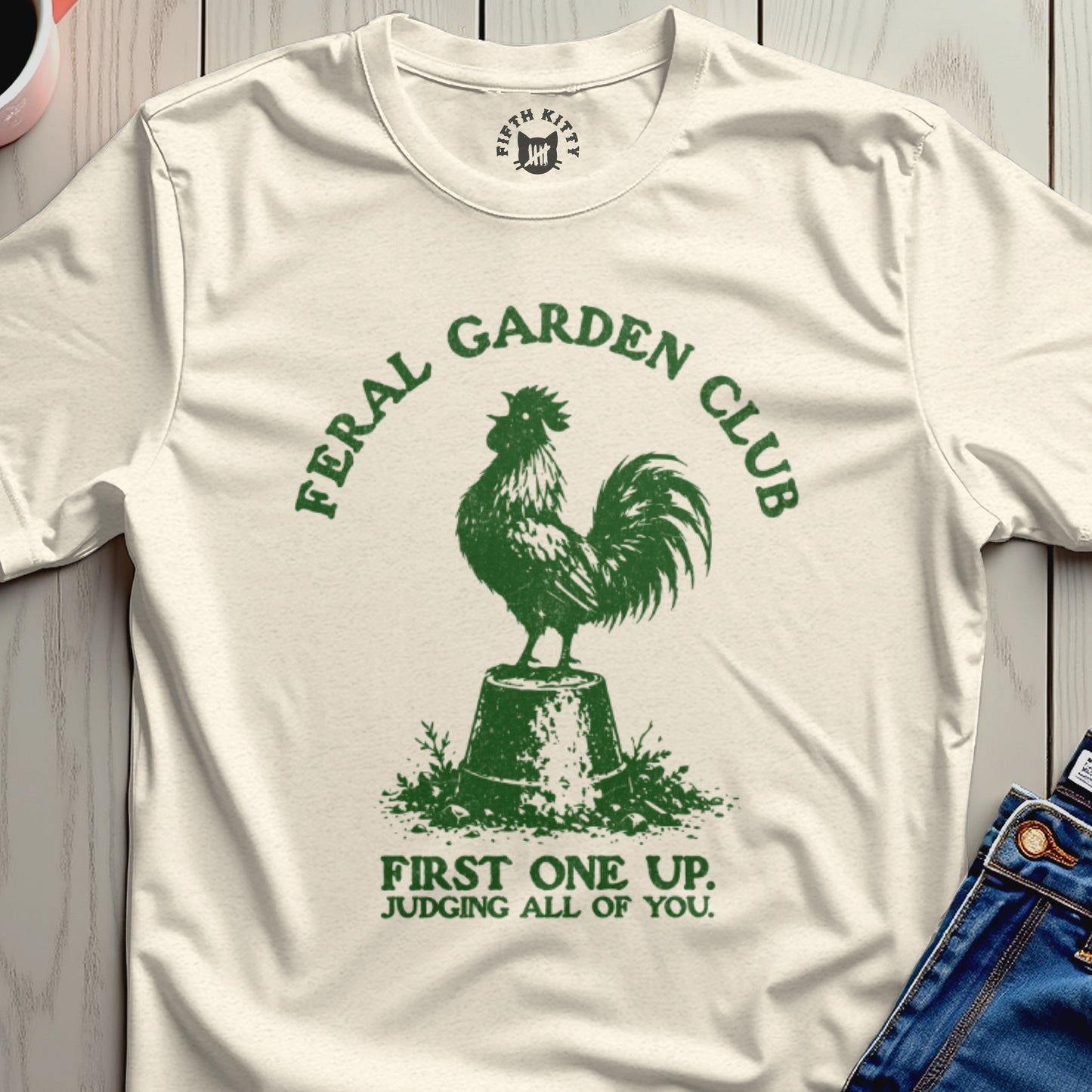 Cream t-shirt with green rooster graphic and "FERAL GARDEN CLUB" text.