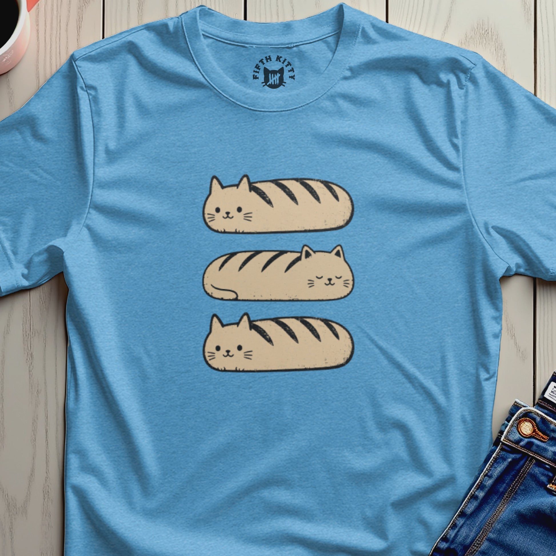 Three cat-shaped loaves with dark stripes stacked on a light blue t-shirt.