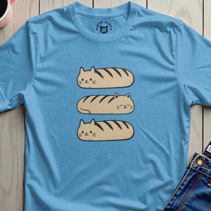 Three cat-shaped loaves with dark stripes stacked on a light blue t-shirt.