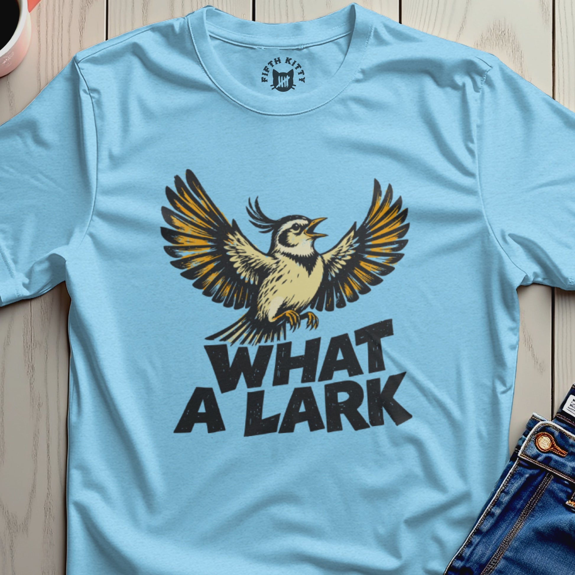 Light blue t-shirt with "What A Lark" text and a bird illustration.