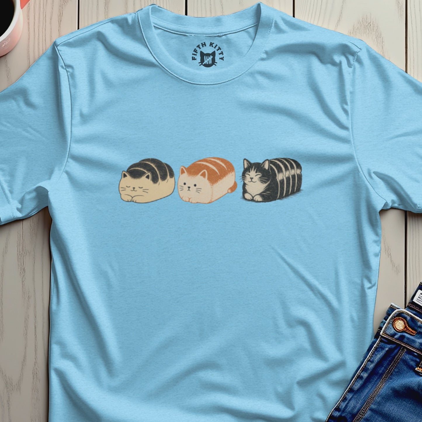 Three cartoon loaf cats with different fur patterns on a light blue t-shirt.