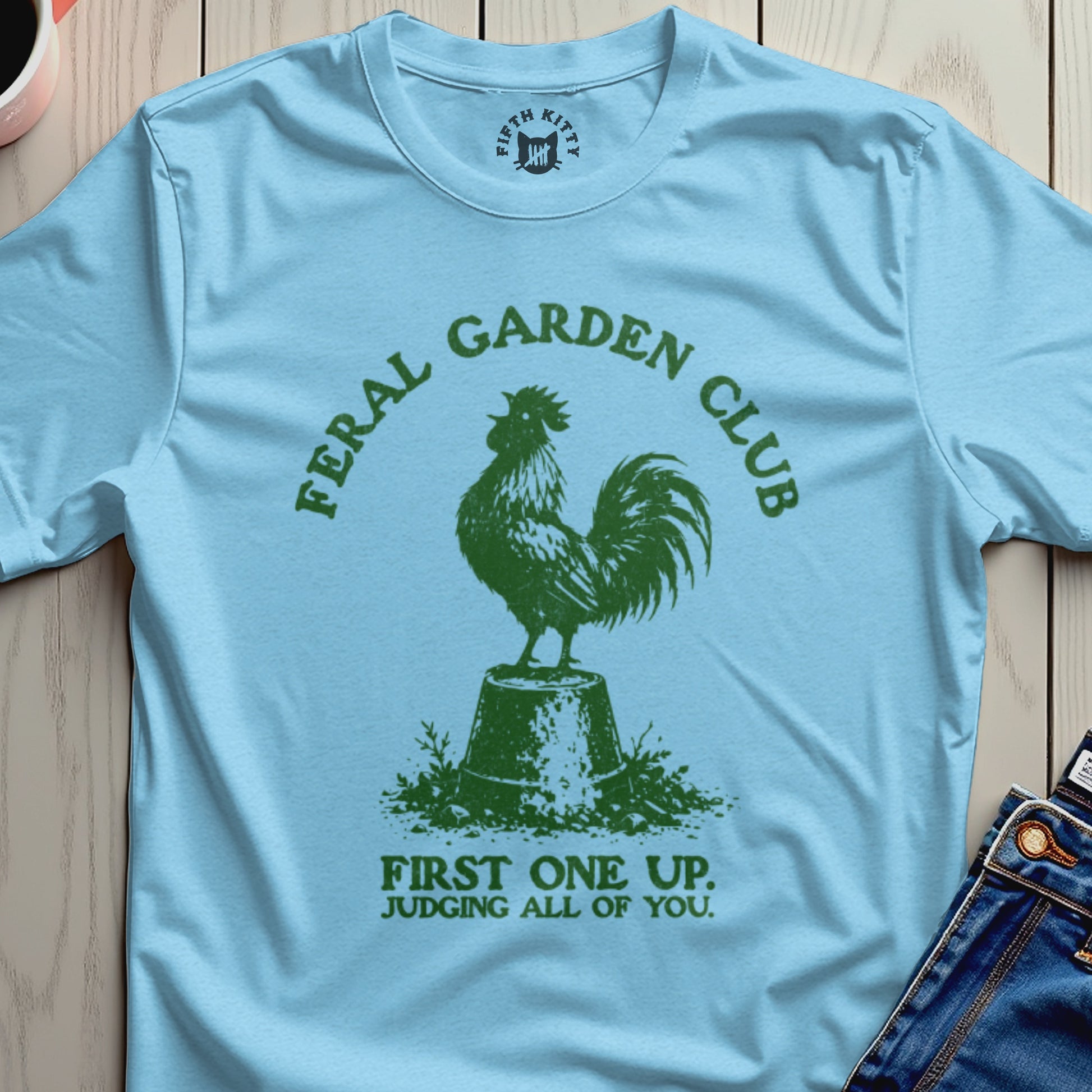 Light blue t-shirt with green feral garden club rooster and text.