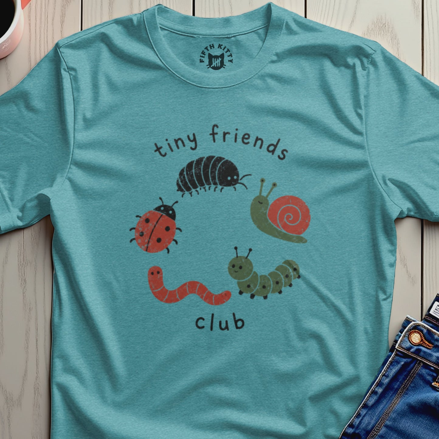 Teal t-shirt with "tiny friends club" text and cartoon bugs.