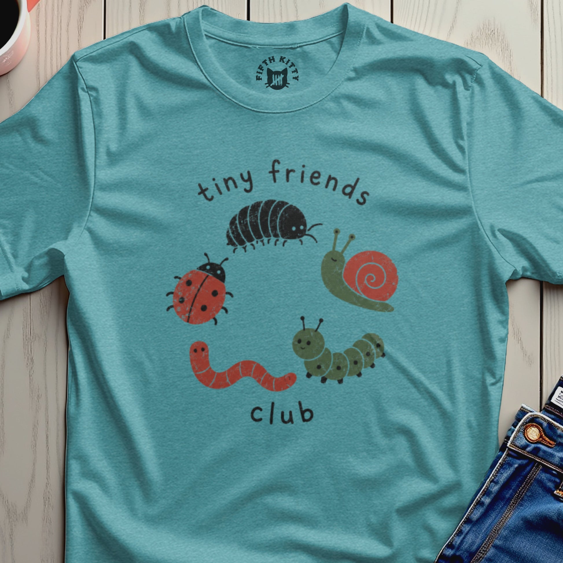 Teal t-shirt with "tiny friends club" text and cartoon bugs.