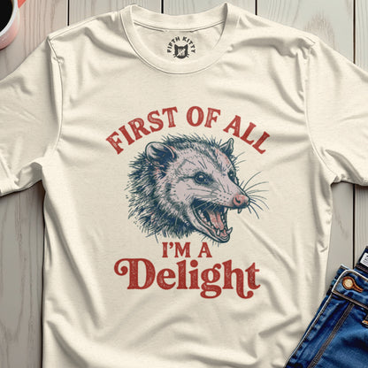 Cream t-shirt with distressed illustration of a possum and text "First of all I'm a Delight".