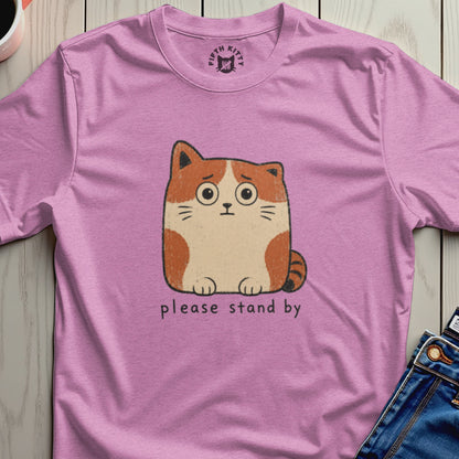 Pink t-shirt with a cartoon cat and the text "please stand by".