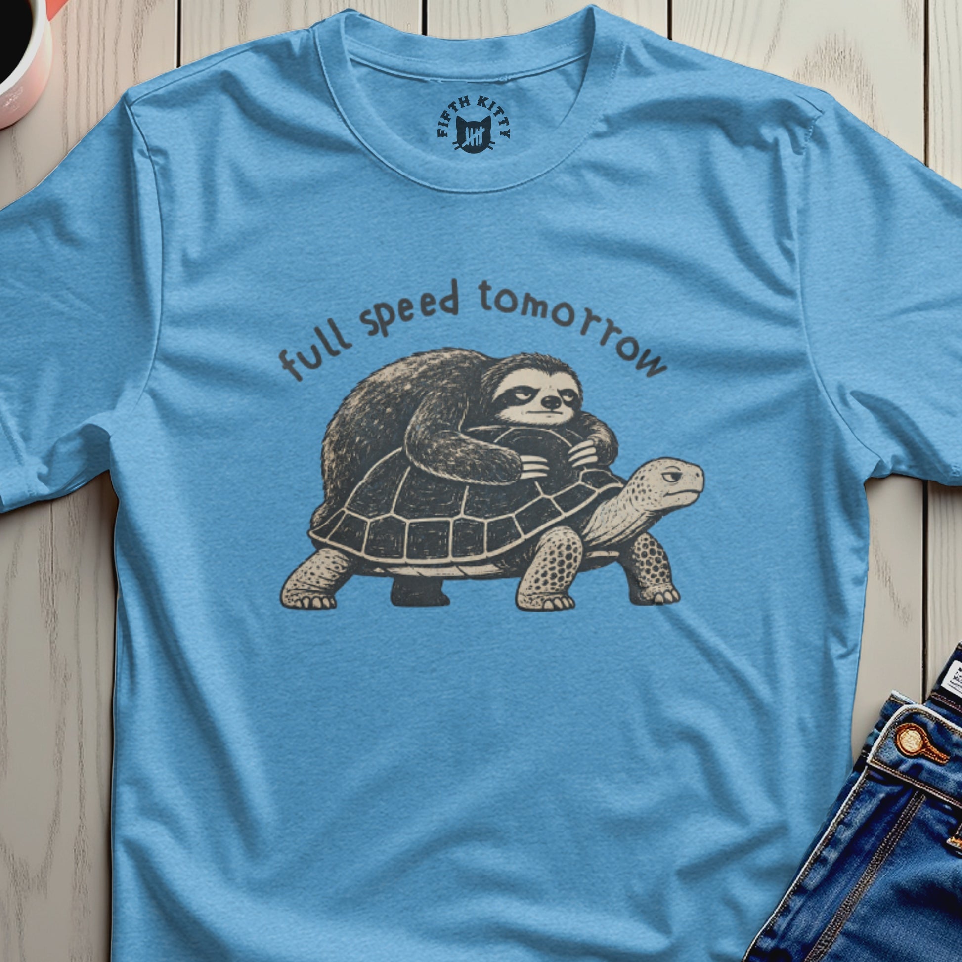 Sloth riding a turtle with text "full speed tomorrow" on blue t-shirt.