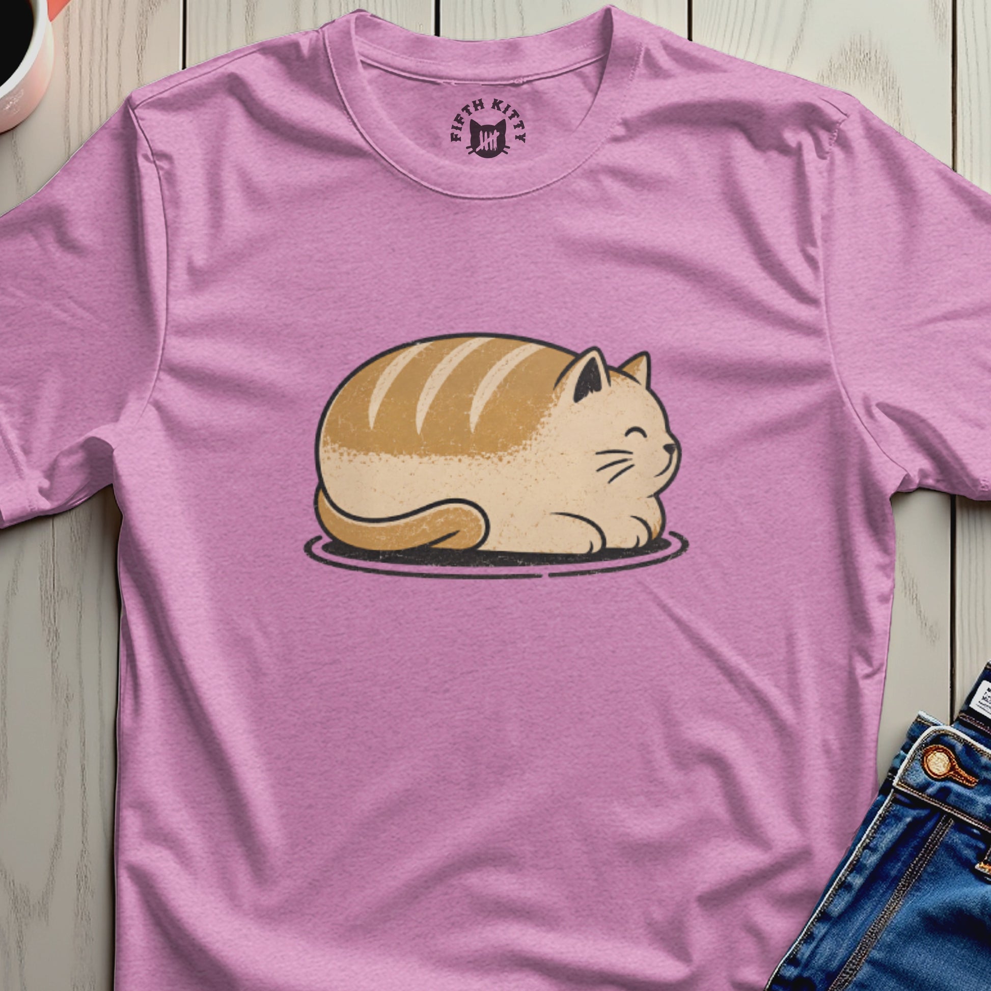 A pink t-shirt with an illustration of a striped cat loaf and a Fifth Kitty logo.