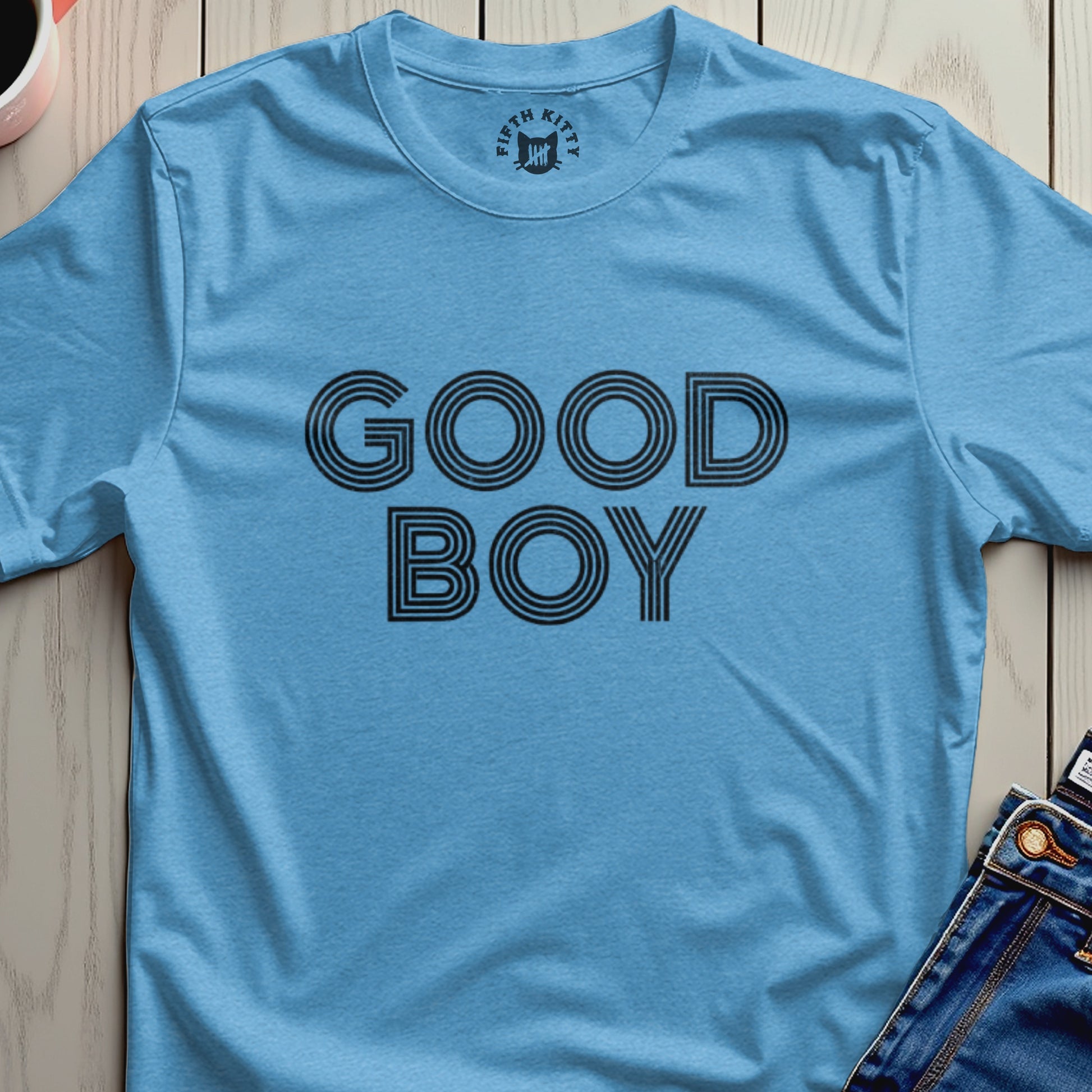 Light blue t-shirt with "GOOD BOY" text in black stripes and a small "FIFTH KITTY" logo.