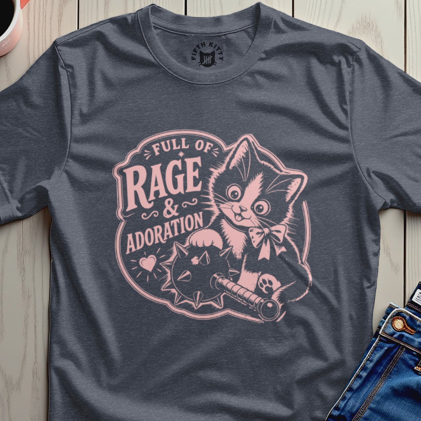 T-shirt with a pink graphic of a kitten holding a spiked ball and cannon.