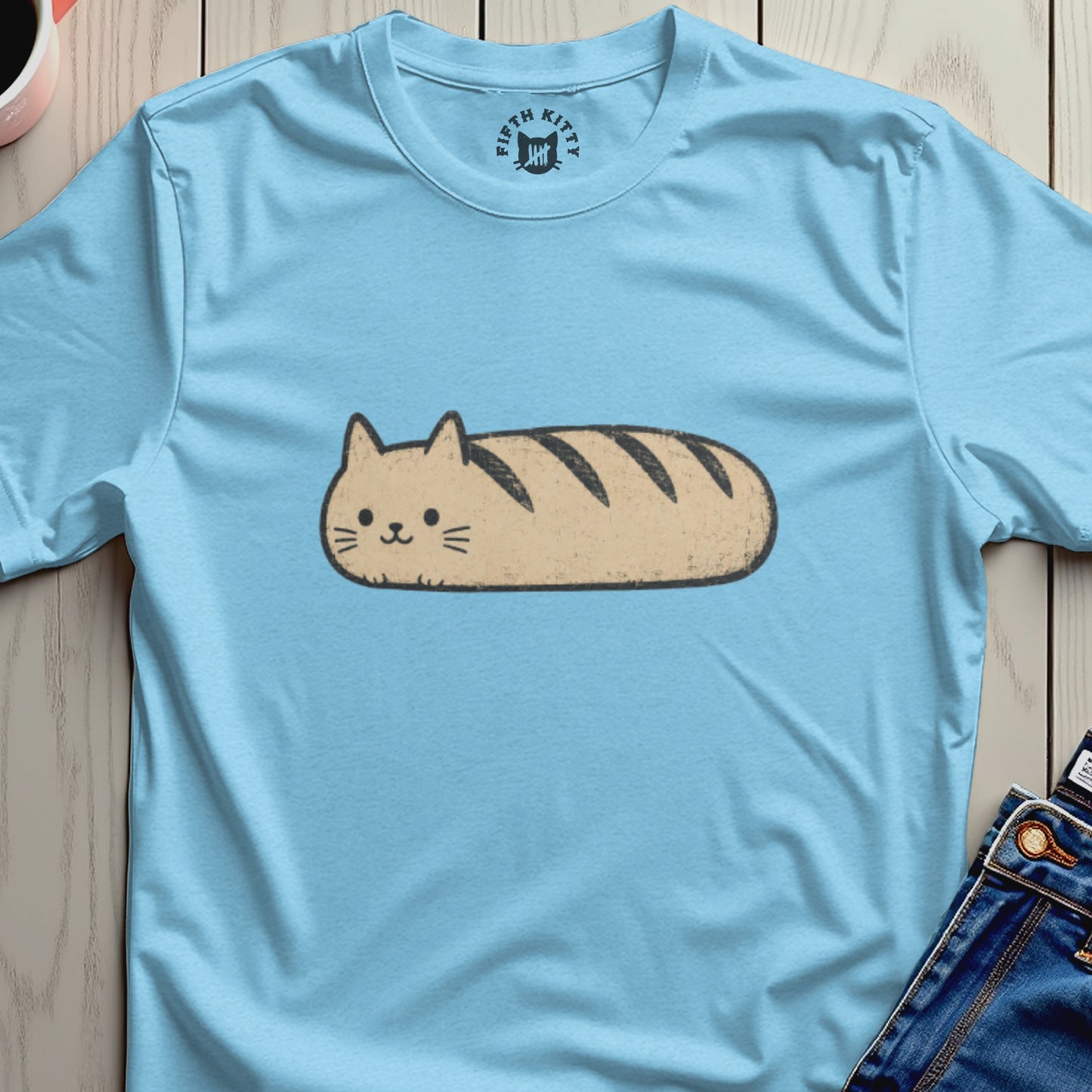 Light blue t-shirt with a cartoon cat shaped like a loaf of bread.