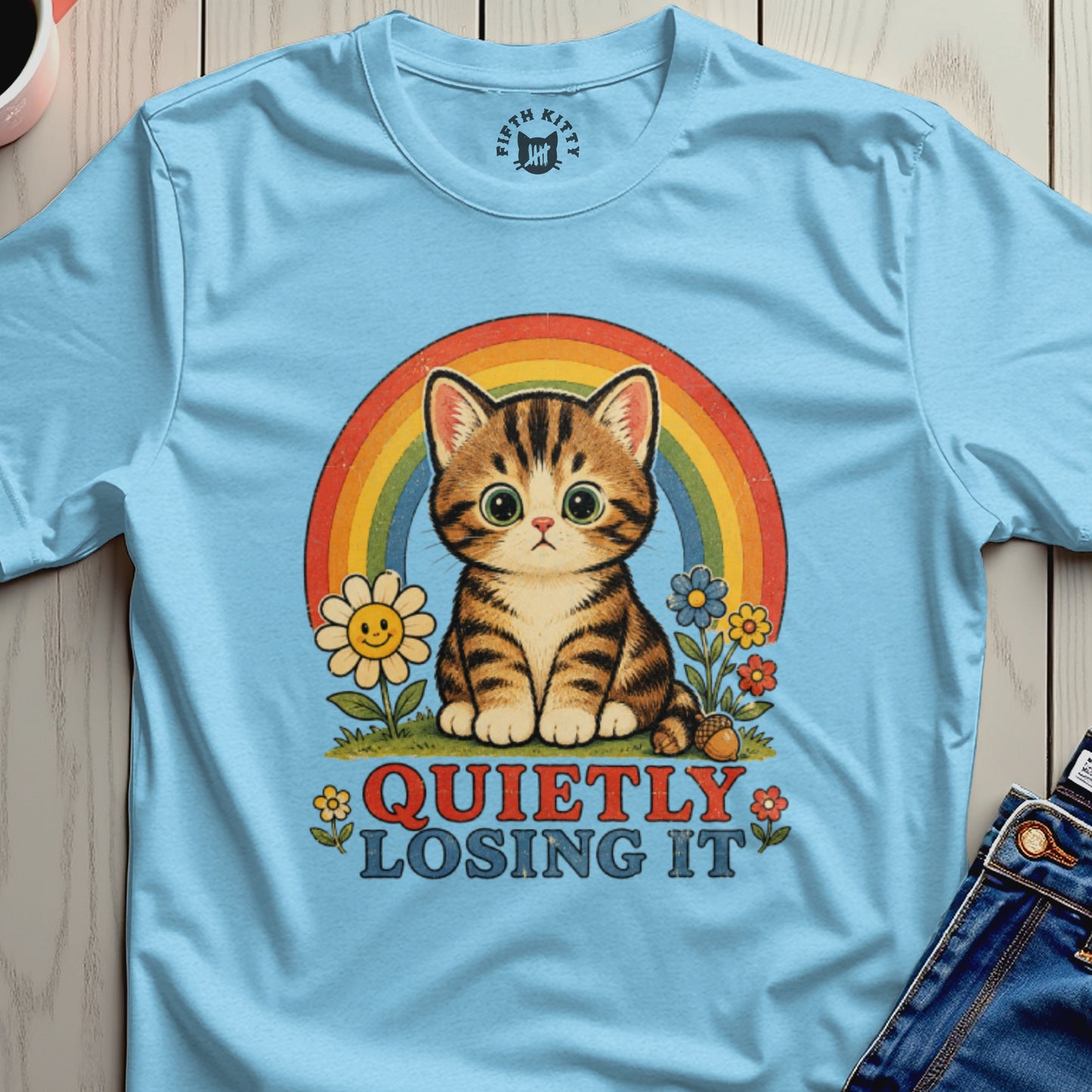 Light blue t-shirt with a tabby cat, rainbow, flowers, and the text "QUIETLY LOSING IT".