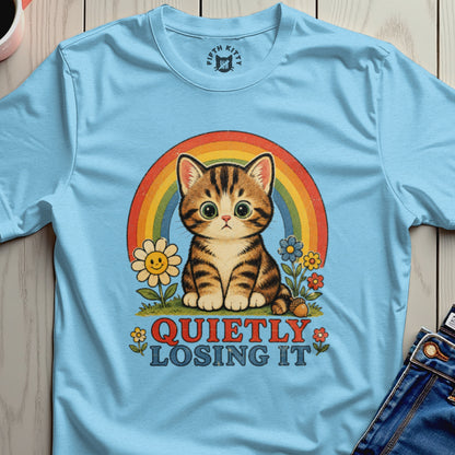 Light blue t-shirt with a tabby cat, rainbow, flowers, and the text "QUIETLY LOSING IT".