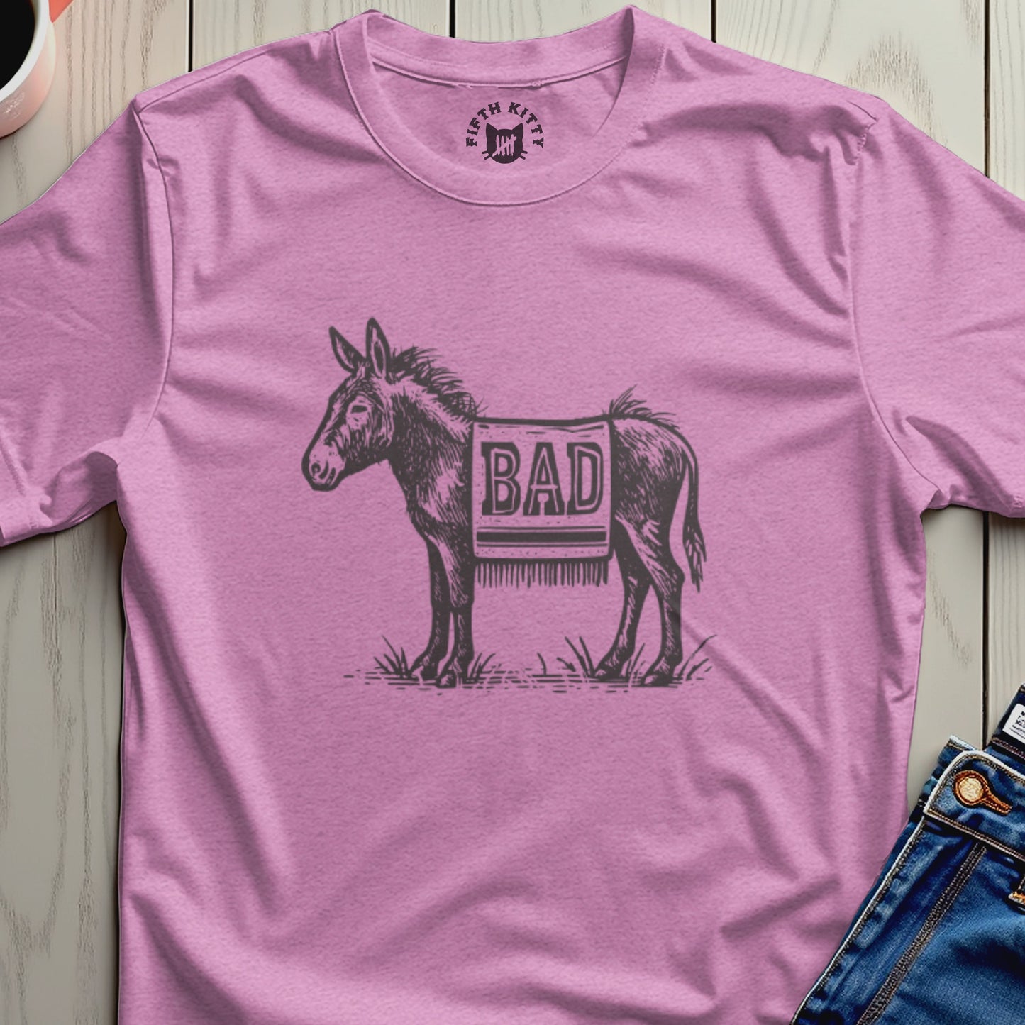 Pink t-shirt with sketch of a donkey wearing a saddle blanket that says "BAD".