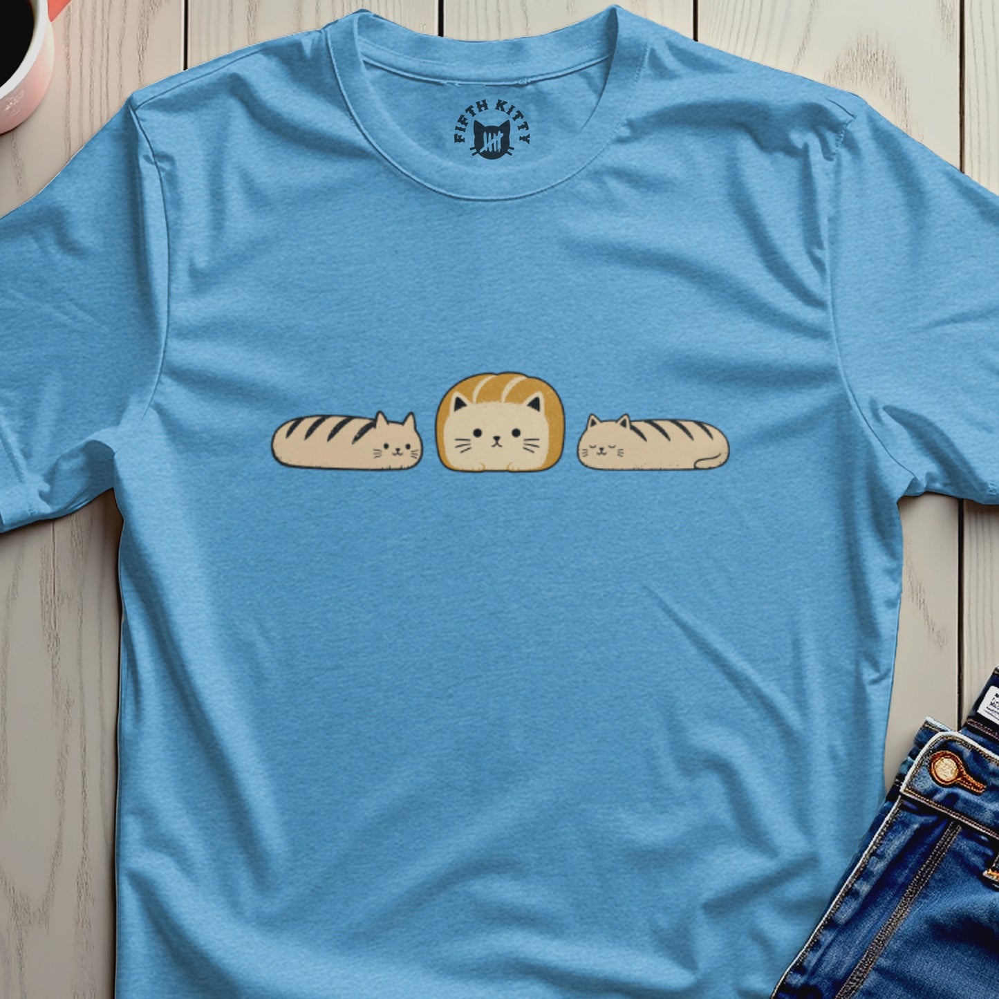 Blue t-shirt with a graphic of three cats, one shaped like bread.
