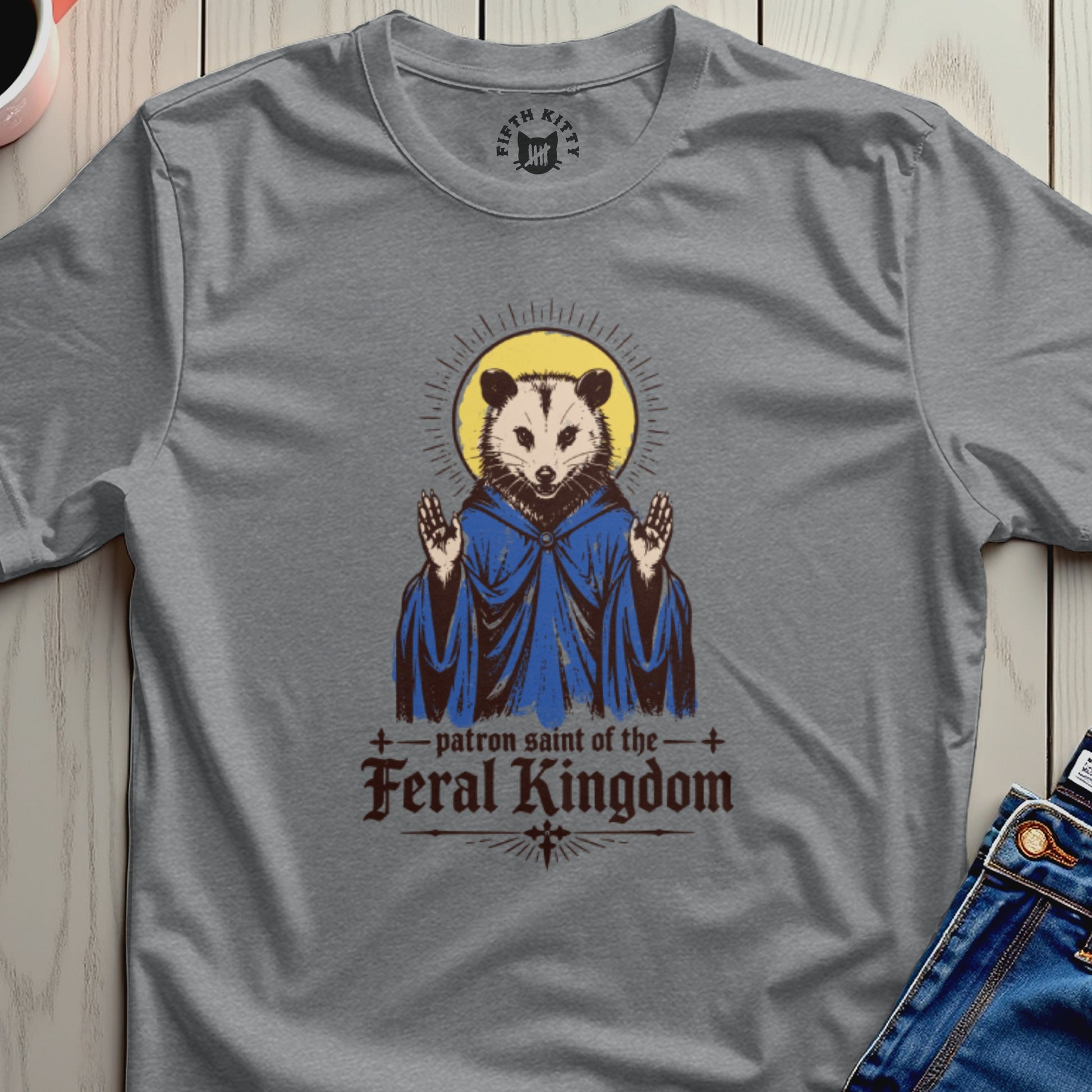 T-shirt graphic of a possum depicted as a saint, wearing a blue robe.