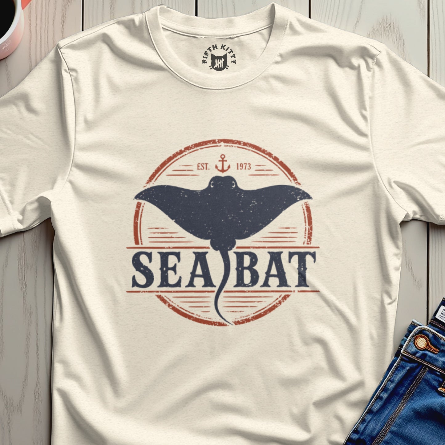 Cream t-shirt with circular distressed graphic of a sea bat, anchor, and text "SEA BAT EST. 1973".