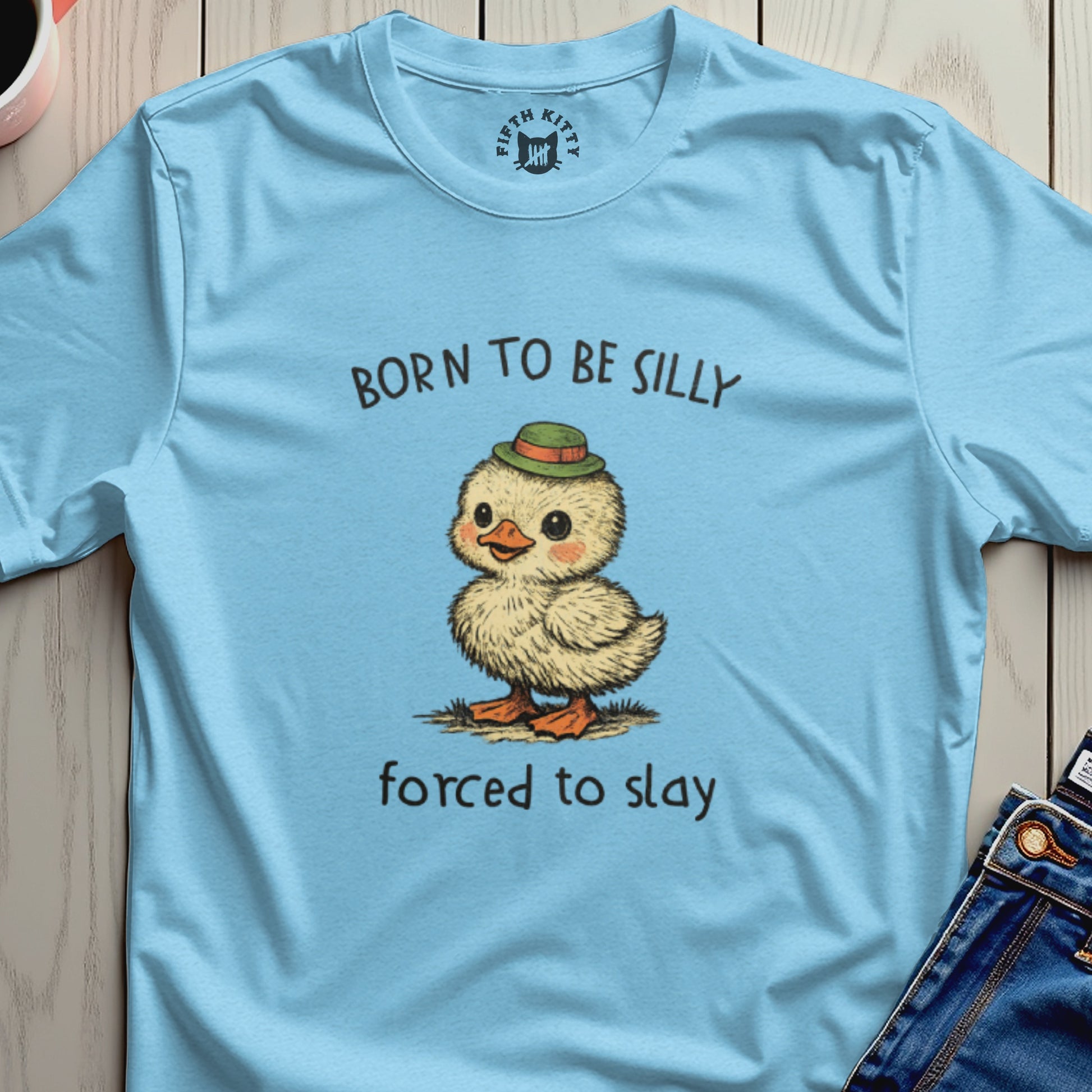 Light blue t-shirt with cartoon chick wearing a hat and text "BORN TO BE SILLY forced to slay".