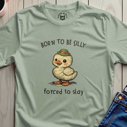 Cartoon chick wearing a green hat, "BORN TO BE SILLY FORCED TO SLAY" text.