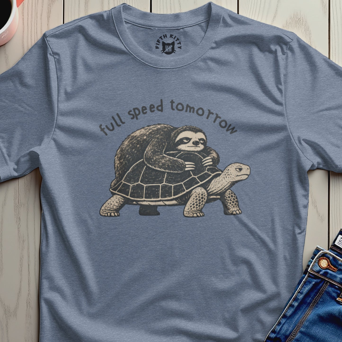 Sloth riding tortoise with text "full speed tomorrow" on slate blue t-shirt.