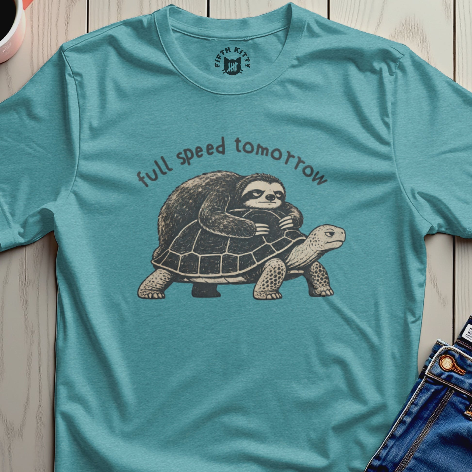 Sloth riding a turtle with text "full speed tomorrow" on a teal shirt.