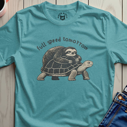 Sloth riding a turtle with text "full speed tomorrow" on a teal shirt.