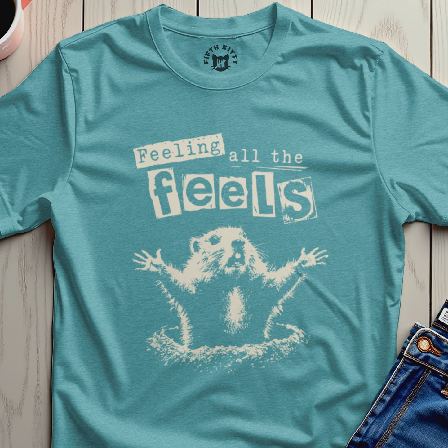 Marmot with arms outstretched, text "Feeling all the feels" on teal t-shirt.