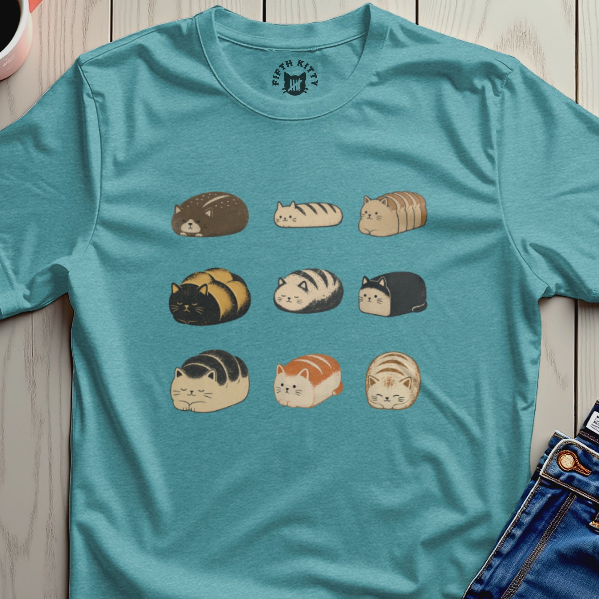 Teal t-shirt with a repeating pattern of loaf-shaped cats and a small Fifth Kitty logo.