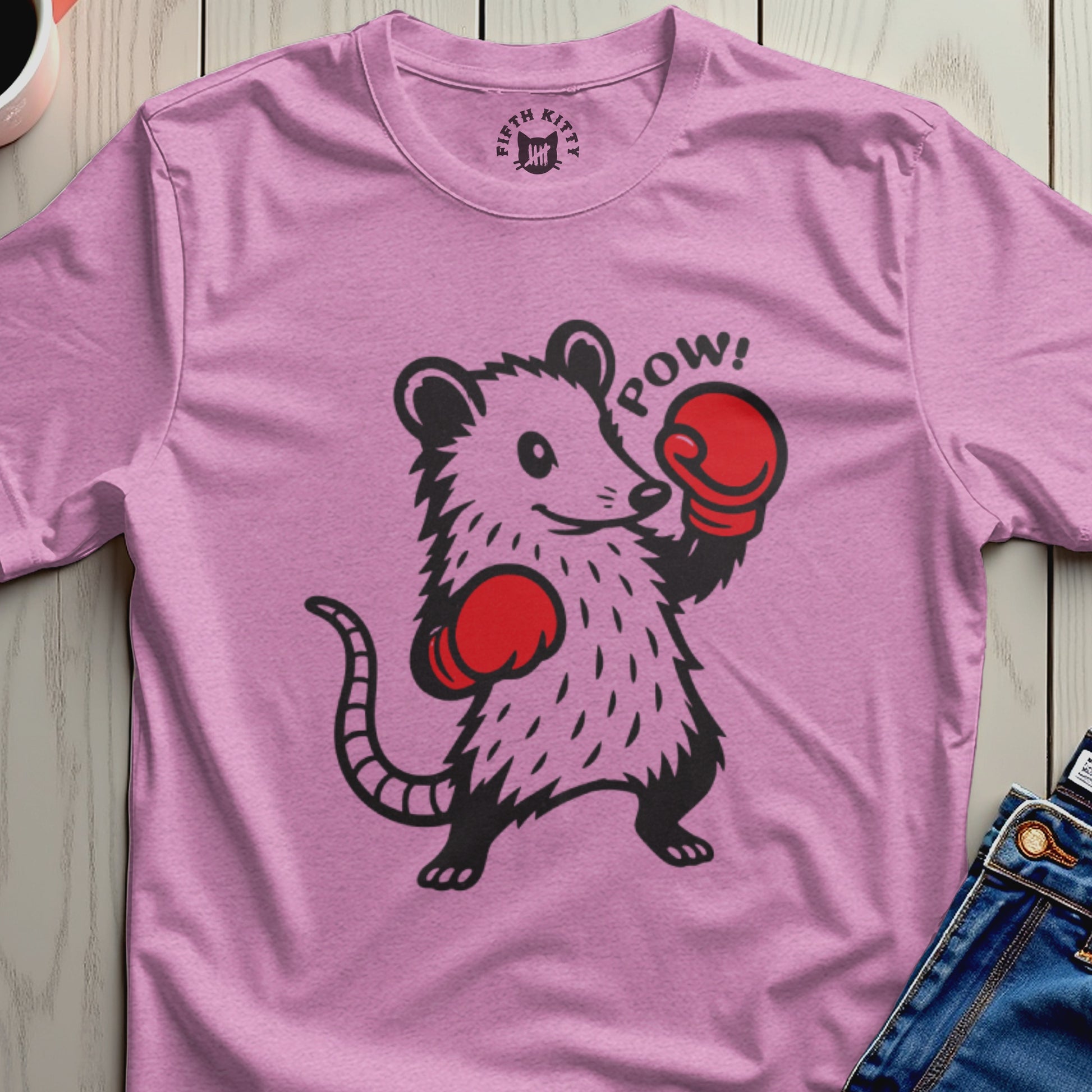 A pink t-shirt with a cartoon opossum wearing boxing gloves and the word "POW!".