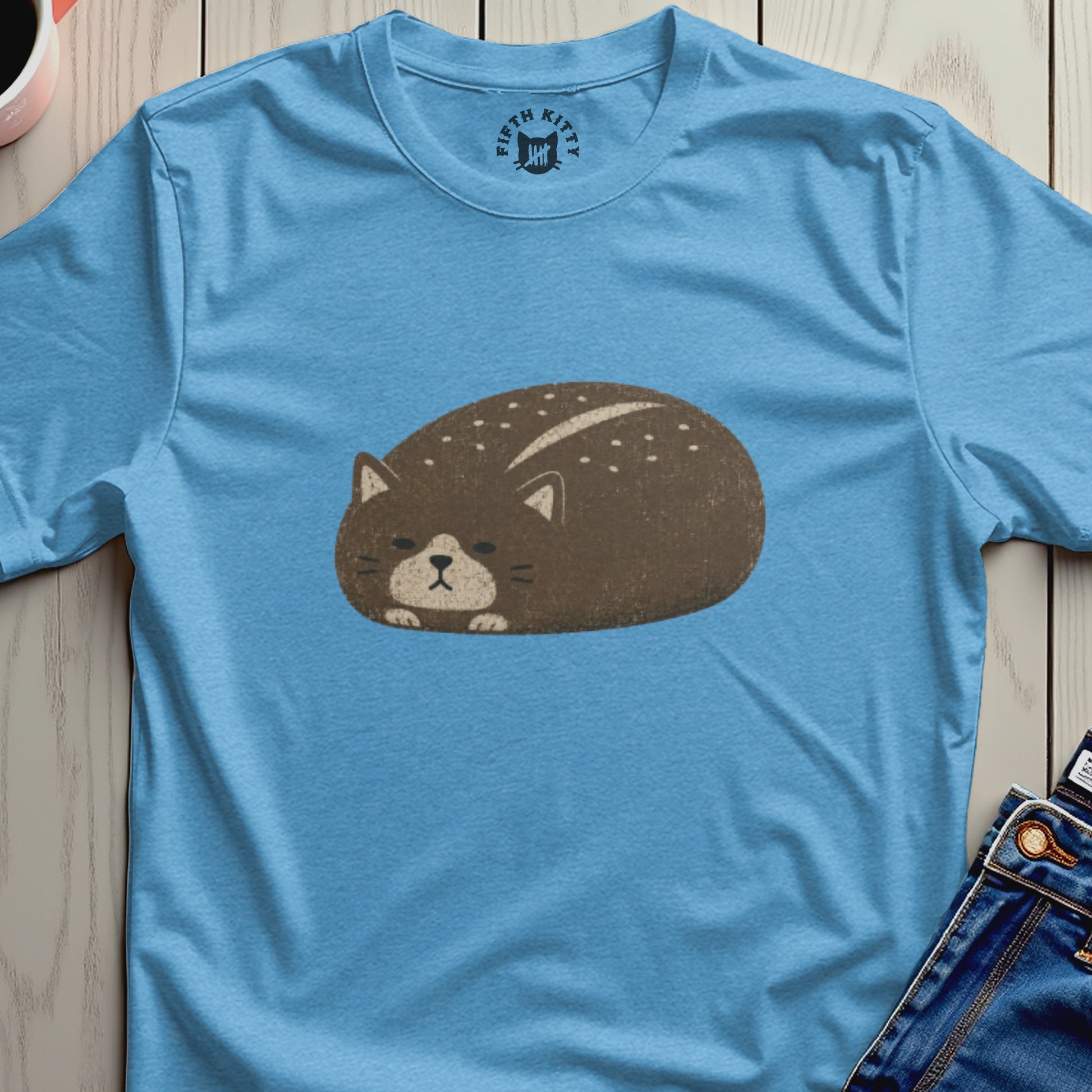 Light blue t-shirt with a round brown cat graphic and "FIFTH KITTY" logo.