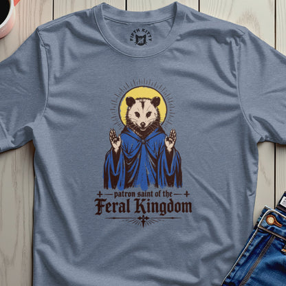 Opossum in blue robe with halo, text reads "patron saint of the feral kingdom".