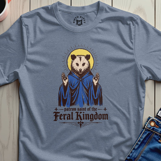 Opossum in blue robe with halo, text reads "patron saint of the feral kingdom".