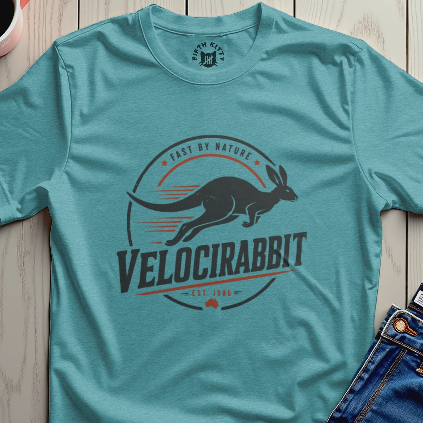 Teal t-shirt with "Velocirabbit Fast By Nature Est. 1986" graphic featuring a running kangaroo.