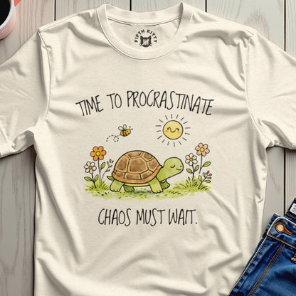 T-shirt with "Time to Procrastinate. Chaos Must Wait." text, turtle, bee, and sun.