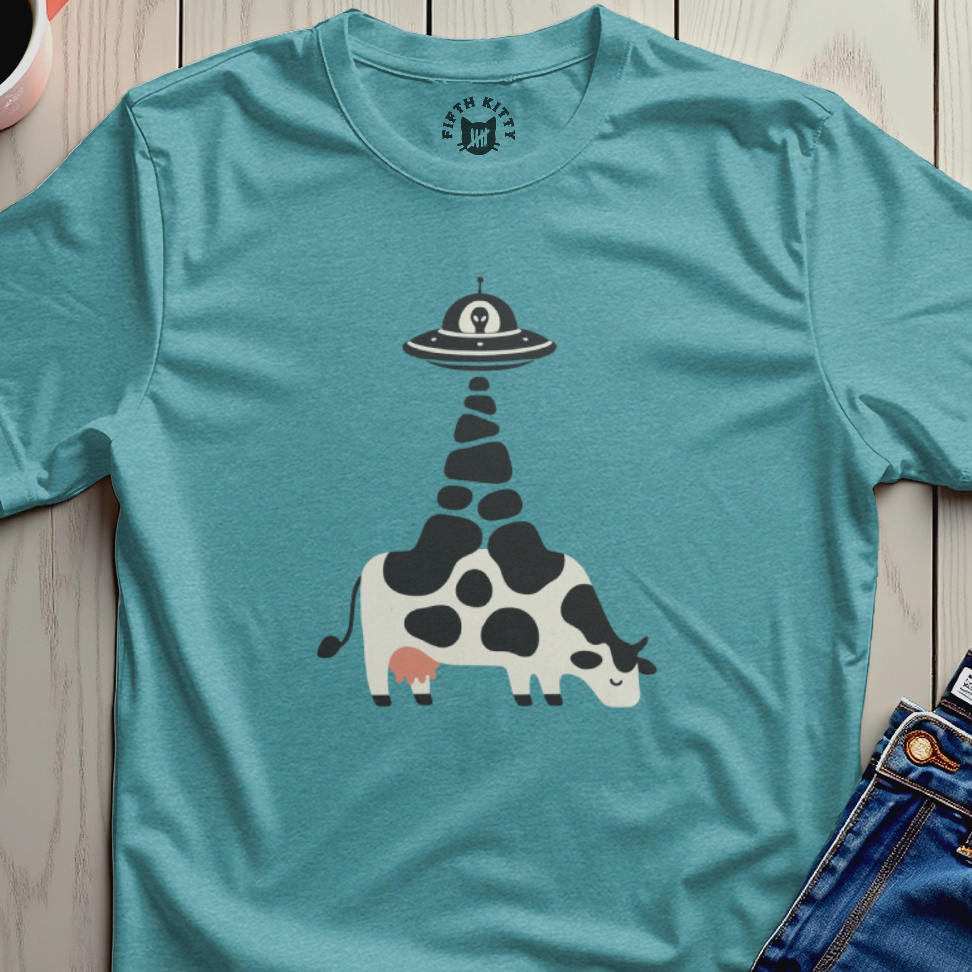 Teal t-shirt with a graphic of a cow being abducted by a UFO.