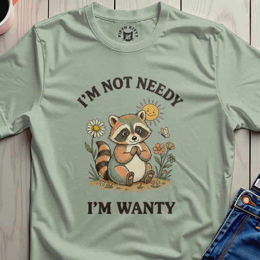 T-shirt with a raccoon illustration, sun, flowers, and text "I'M NOT NEEDY I'M WANTY".