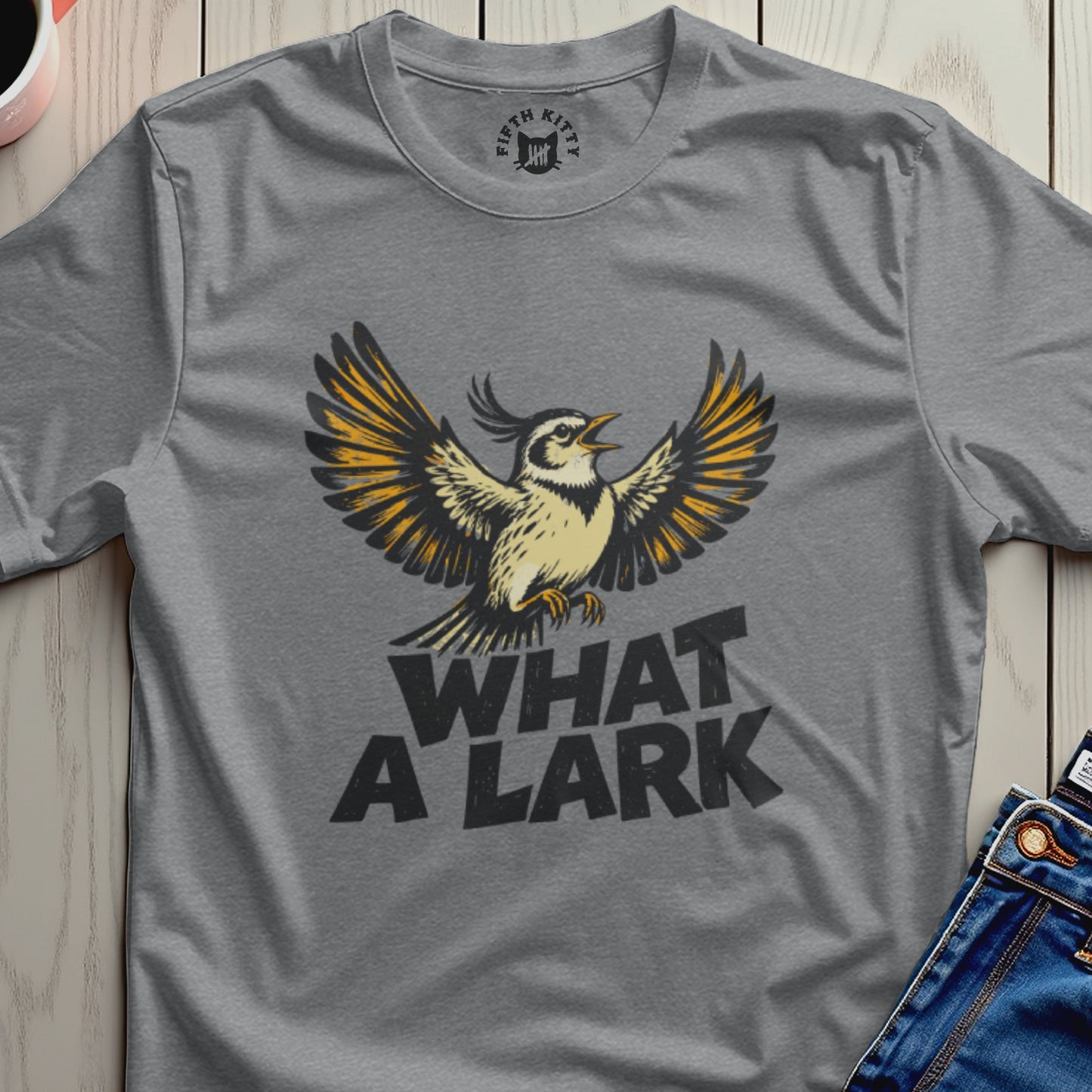 Gray t-shirt with "WHAT A LARK" and a yellow and black bird with outstretched wings.