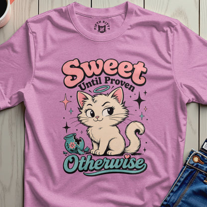 Pink t-shirt with a cream cat, broken vase, and "Sweet Until Proven Otherwise" text.
