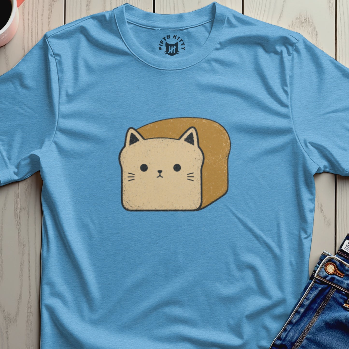 A light blue t-shirt with a graphic of a cat head on a toast slice.
