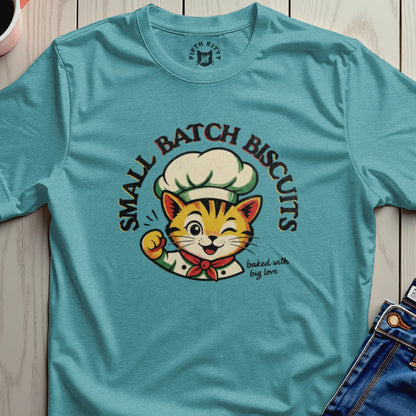 Teal t-shirt with a chef cat design and text "Small Batch Biscuits baked with big love".