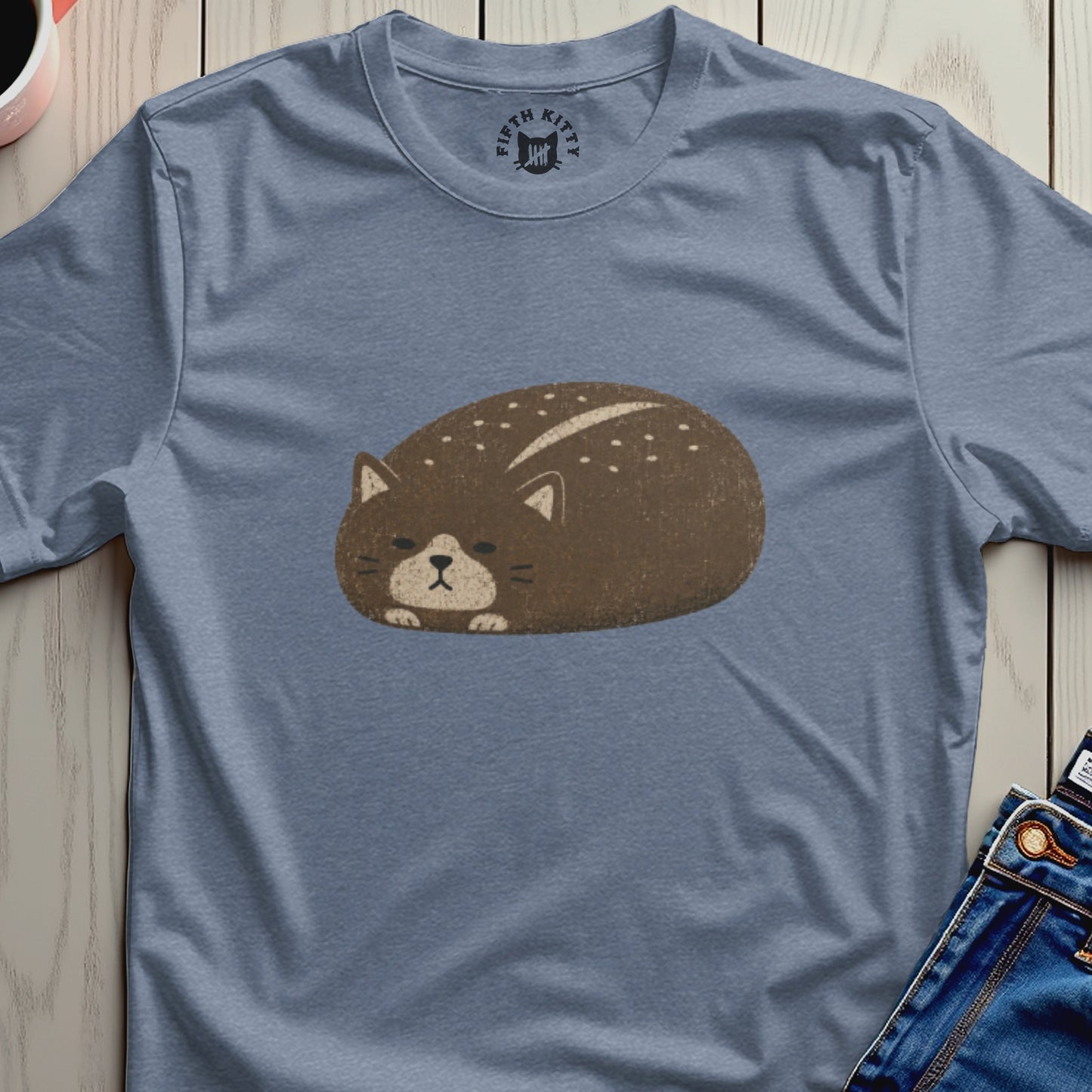 Brown cat loaf illustration with white dots on a blue t-shirt.