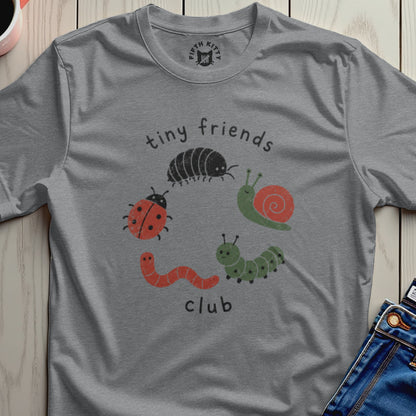 A grey t-shirt with "tiny friends club" and cartoon insects printed on it.