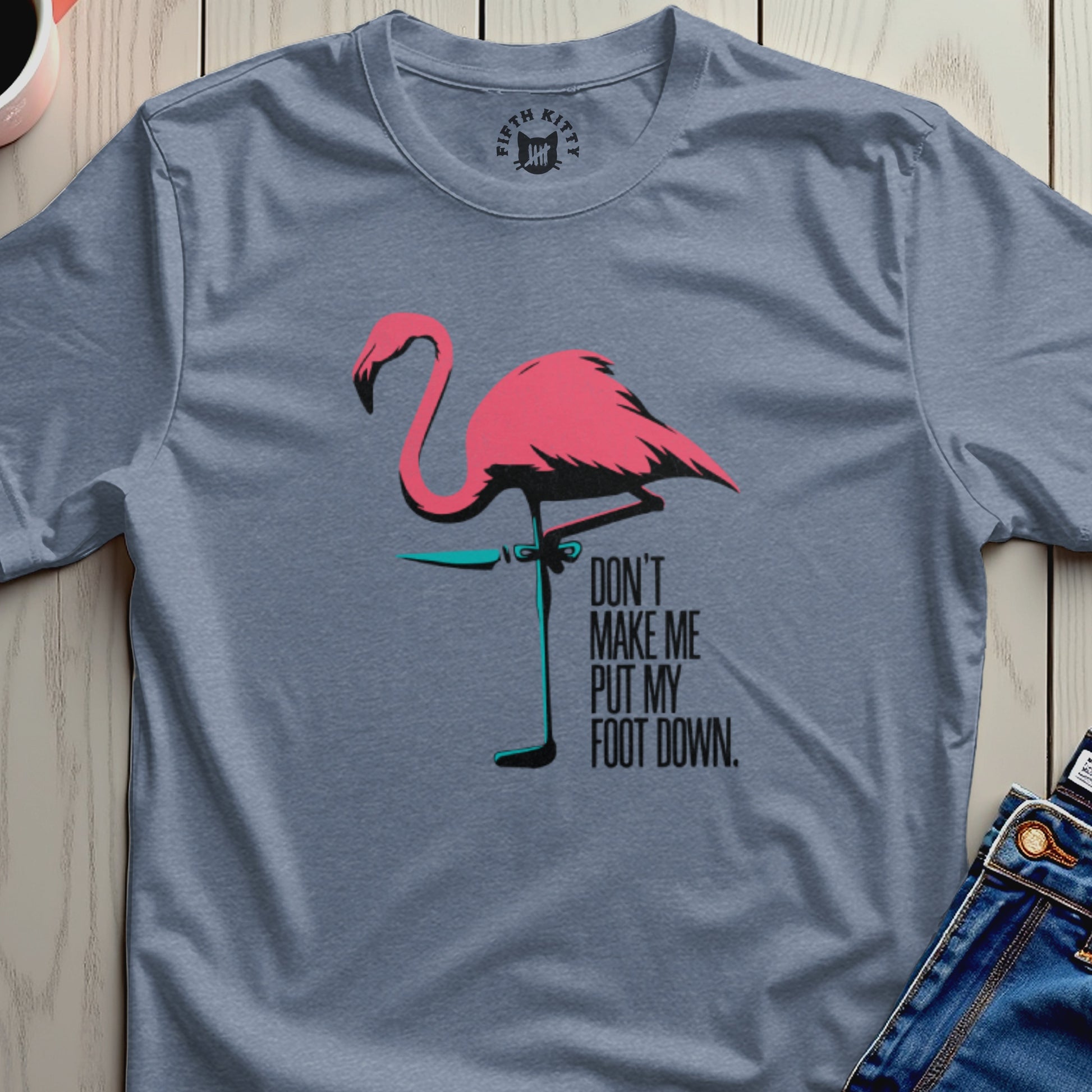 Blue t-shirt with a pink flamingo graphic and text "DON'T MAKE ME PUT MY FOOT DOWN."