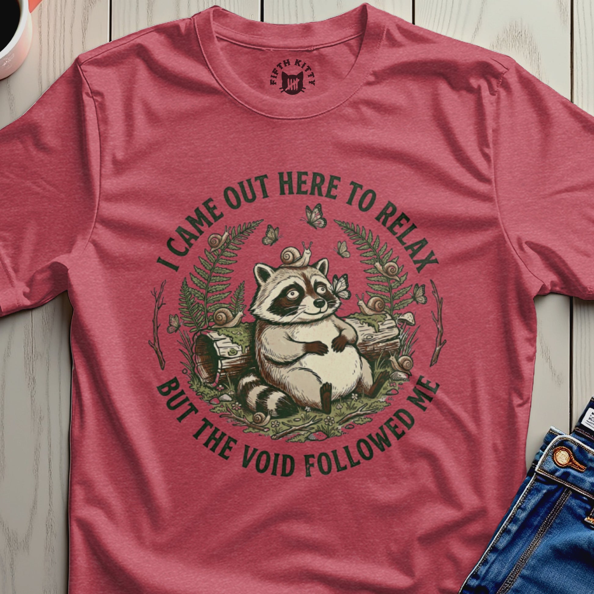 Raccoon sitting in a forest clearing with text "I CAME OUT HERE TO RELAX BUT THE VOID FOLLOWED ME".