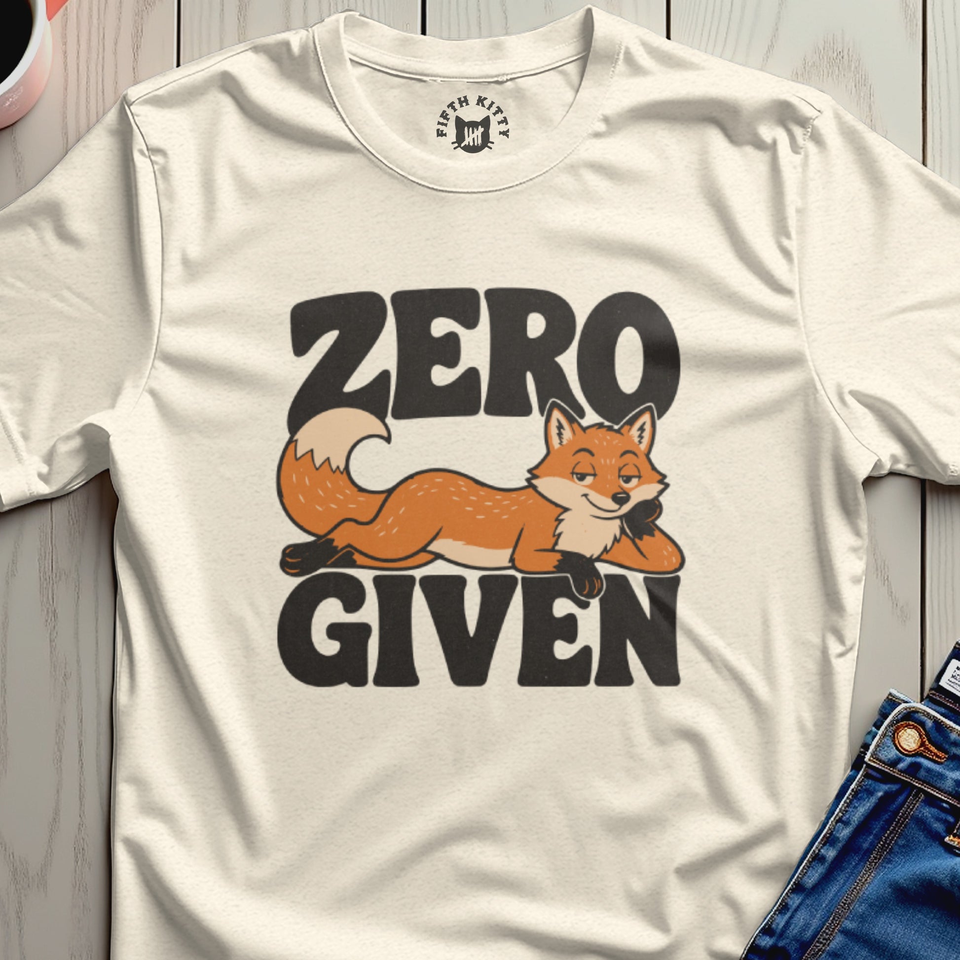 Cream t-shirt with "ZERO GIVEN" text and a relaxed fox illustration.