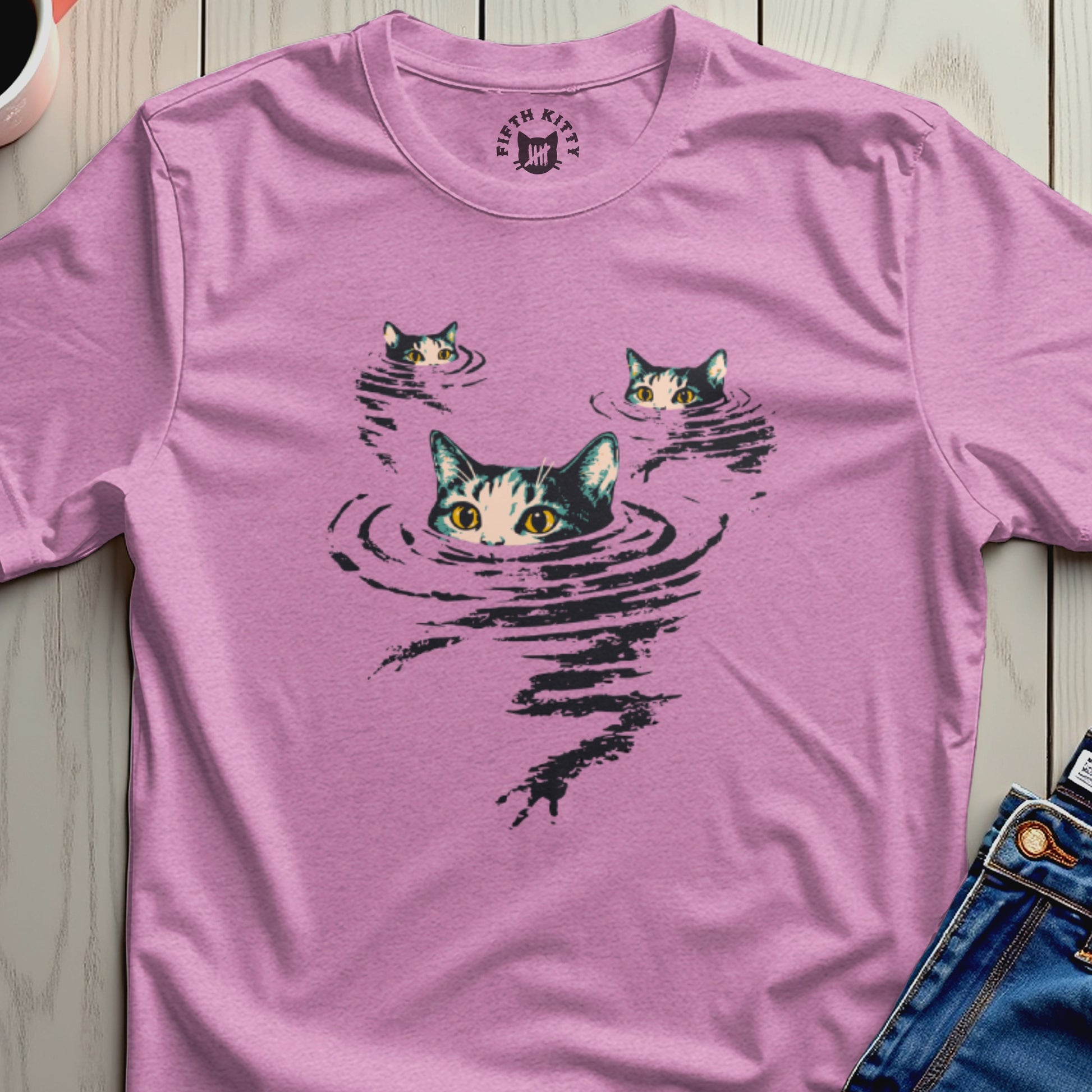 Three cat faces emerge from rippling water graphic on a pink t-shirt.