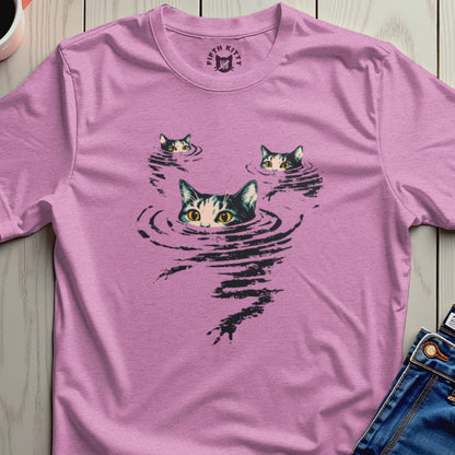 Three cat faces emerge from rippling water graphic on a pink t-shirt.