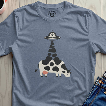 Black and white cow with an alien spaceship beam on a blue t-shirt.