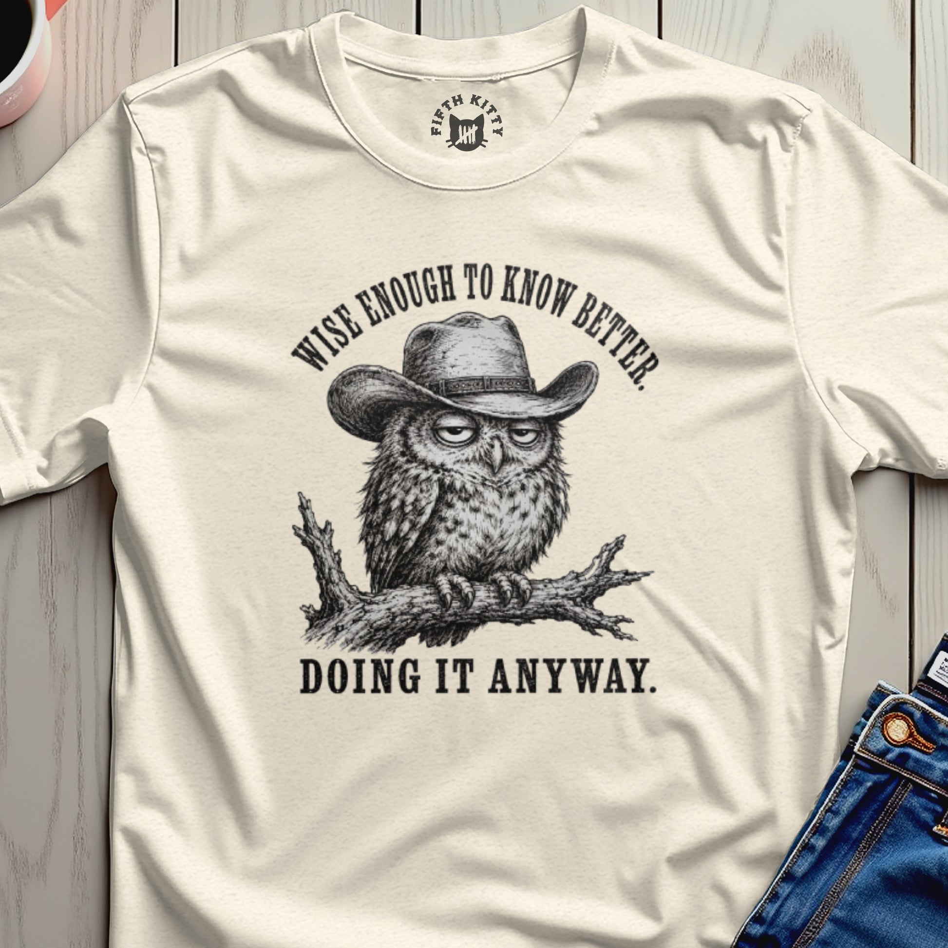 Cream t-shirt with owl wearing cowboy hat and text "Wise enough to know better. Doing it anyway."
